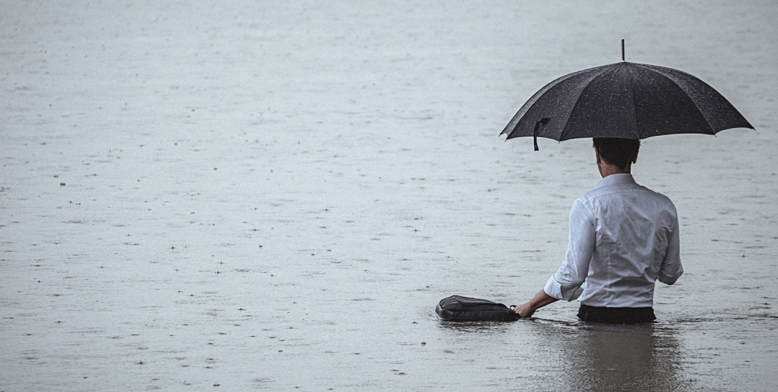 Mann mit Regenschirm im See